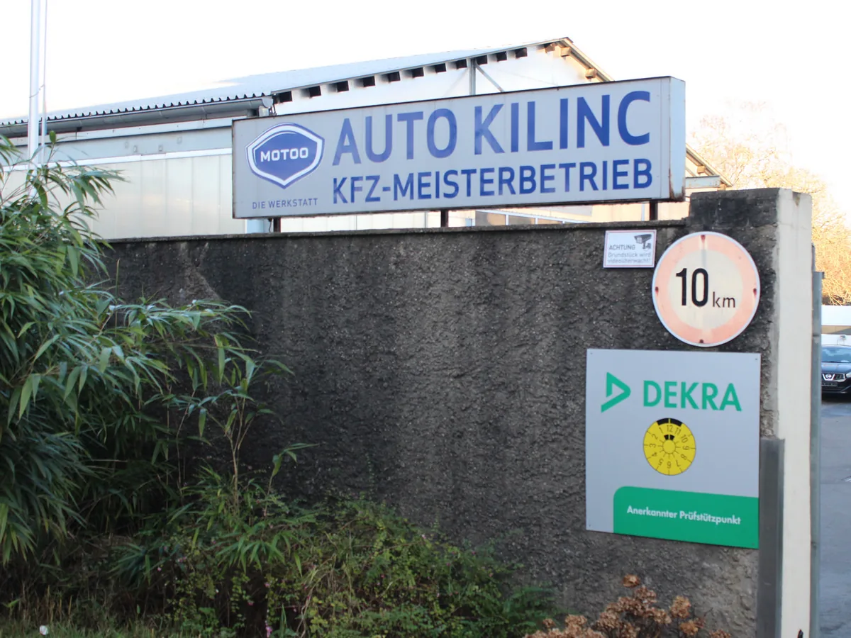 Einfahrt zu Auto Kilinc mit Firmenschild und DEKRA-Prüfstützpunkt-Schild